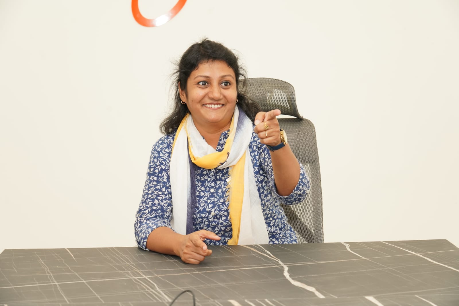 Srimathi Krishnan - Professional leadership coach and wellness mentor giving thumbs up in office setting